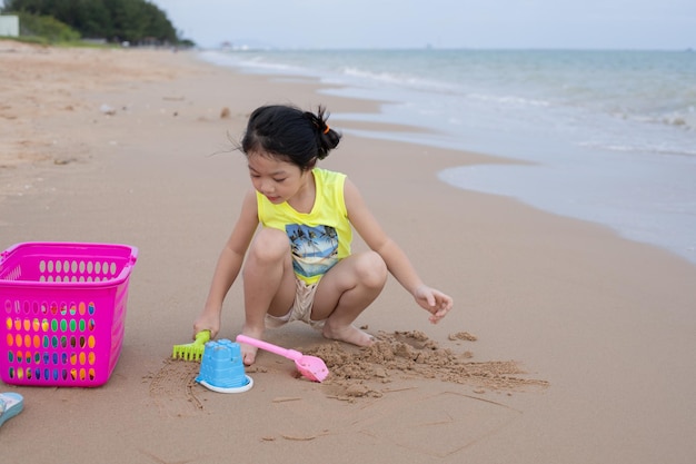 Een jong meisje dat zand speelt op het strand