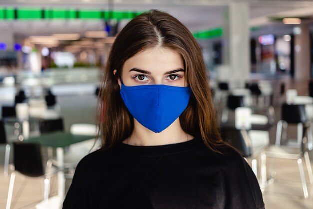 Een jong meisje draagt een gezichtsmasker dat beschermt tegen de verspreiding van de coronavirusziekte