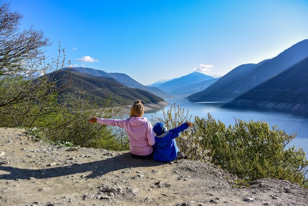 Een jong meisje en een kleine jongen op de achtergrond van het landschap van het Zhinvali-reservoir Georgia 2019