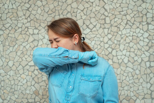 Een jong meisje in een blauw shirt en beschermende handschoenen