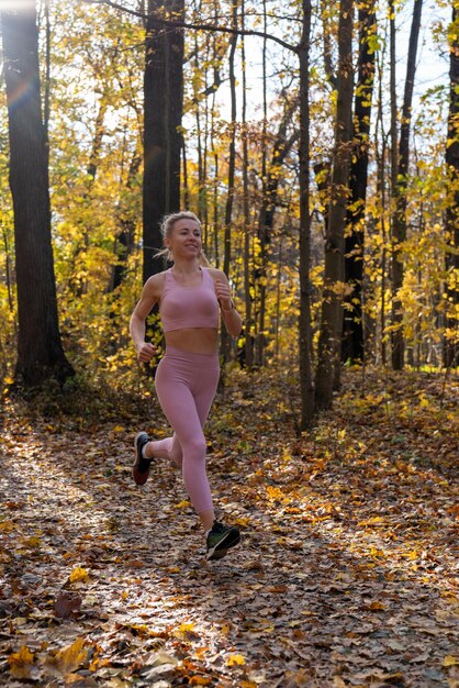 Een jong meisje in een sportuniform Sport Joggen in het herfstpark Geel gebladerte Actieve levensstijl Mens en natuur Gezonde levensstijl Hardlopen