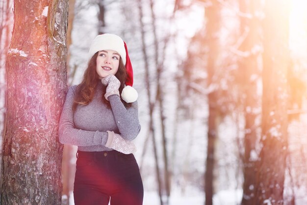 Een jong meisje in een winterpark op een wandeling. Kerstvakantie in het winterbos. Meisje geniet van de winter in het park.