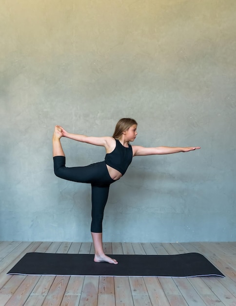 Een jong meisje in sportkleding doet yoga-fitness thuis sporten thuis stretching