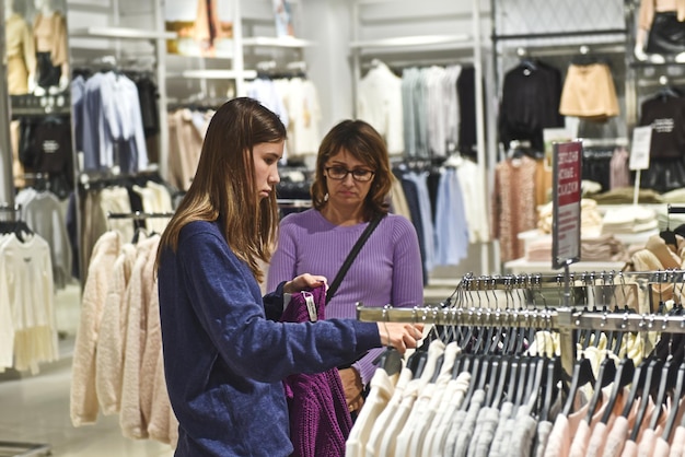 Een jong meisje is aan het winkelen in een kledingwinkel