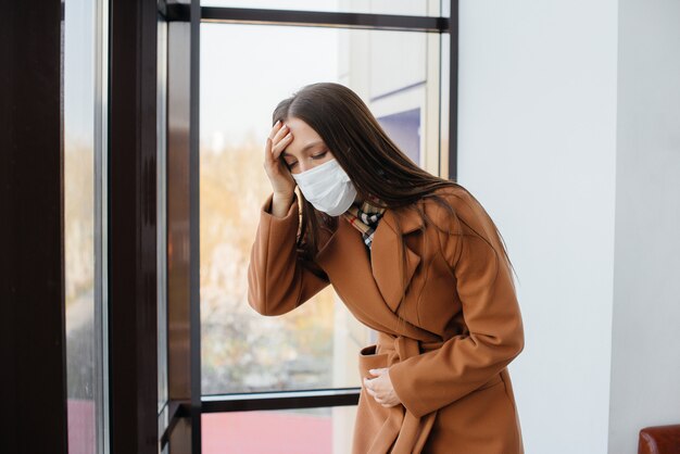 Een jong meisje loopt in een masker tijdens de pandemie en het coronovirus. Quarantaine.