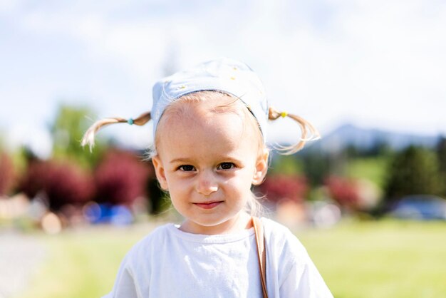 Een jong meisje met een hoed en een blauwe bandana.