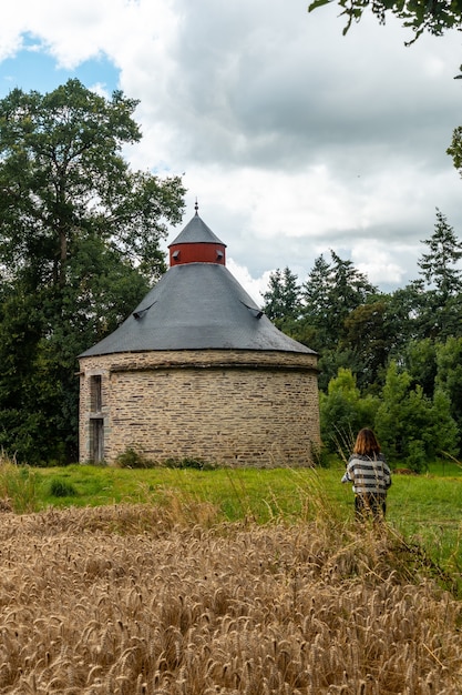 Een jong meisje naast de rietgedekte schuur in Frans Bretagne in de zomer van juli, in de buurt van het Broceliande-bos.