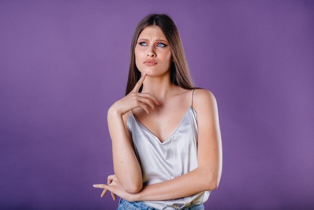 Een jong meisje poseren in studio met paarse muur