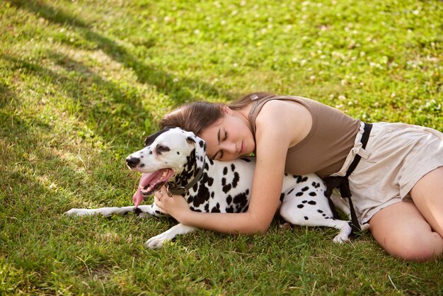 een jong meisje speelt met een Dalmatiër in het park hondenzorgconcept