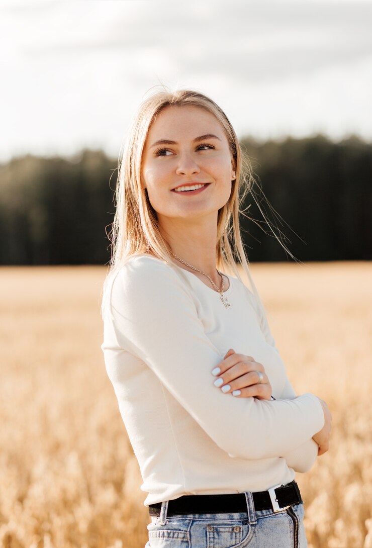 Foto een jong mooi meisje in een spijkerrok loopt op een zonnige dag door een tarweveld