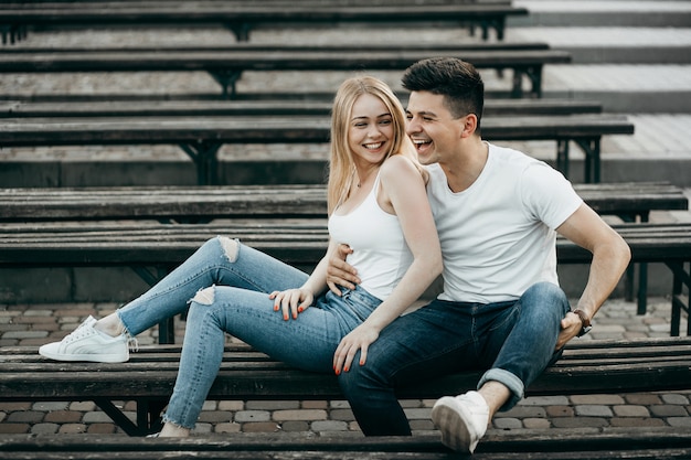 Een jong paar in liefde knuffelen op de bank in het park