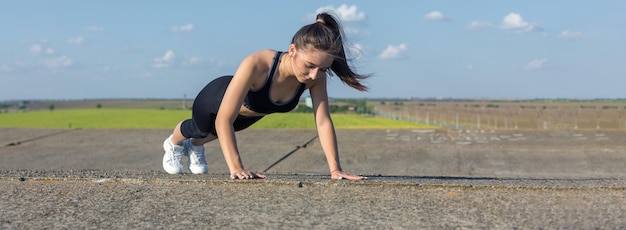 Een jong slank atletisch meisje in sportkleding met slangenhuidprints voert een reeks oefeningen uit Fitness en een gezonde levensstijl