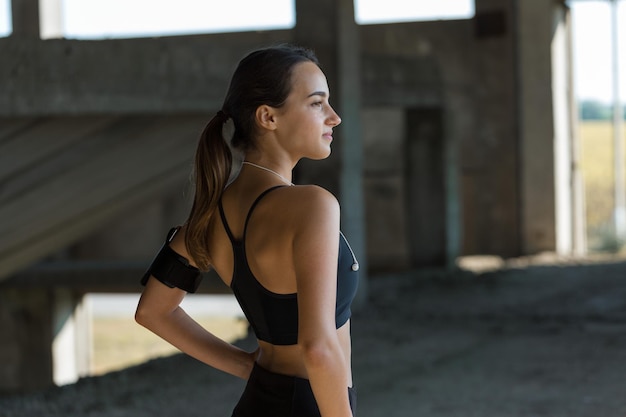 Een jong slank atletisch meisje in sportkleding voert een reeks oefeningen uit Fitness en een gezonde levensstijl