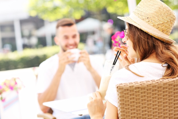 Een jong stel dat tijdens de zomerdag in het café zit?