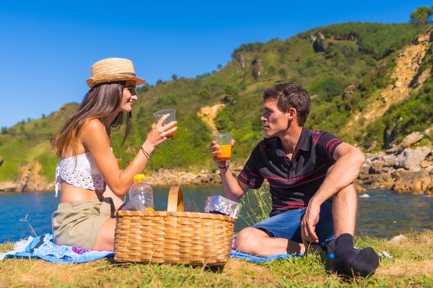 Een jong stel op een picknick in de bergen aan zee, genietend van de zomer