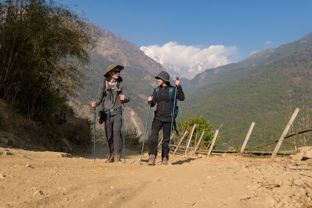 Een jong stel reizigers op trektocht in het uitkijkpunt poon hill in ghorepani, nepalx9