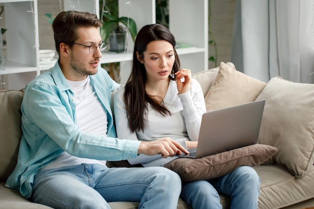 Een jong stel werkt achter een laptop