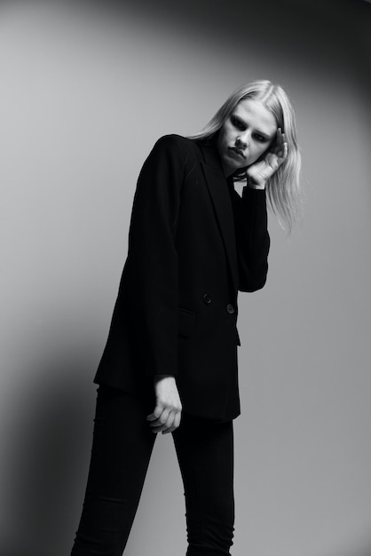Een jong stijlvol meisje in een jas poseert in een zwart-wit studio Een concept voor kledingmerken Cool aanbieding banner te koop