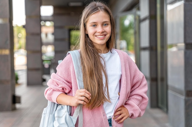 Een jong tienermeisje gaat met een rugzak naar school. Een tienerstudent of een schoolmeisje. opleiding