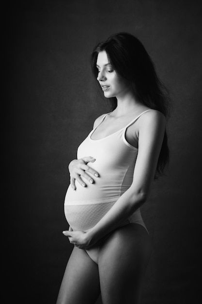Een jong zwanger meisje in een jurk.