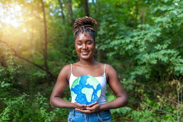 Een jonge Afro-Amerikaan met gevlochten haar die een planeet aarde vasthoudt en protesteert tegen milieuvervuiling