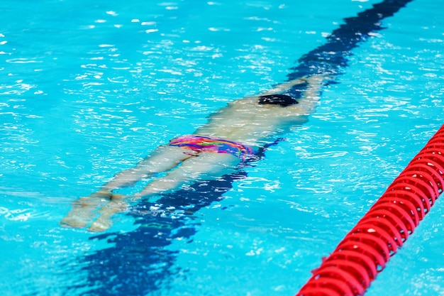 Een jonge atletische tiener zwemt onder water