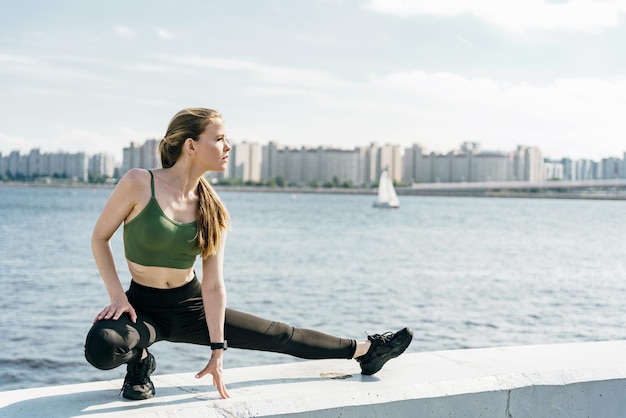 Een jonge atletische vrouw heeft een sterke persoonlijkheid. Gebruikt een fitnesshorloge Fitnesswarming-up