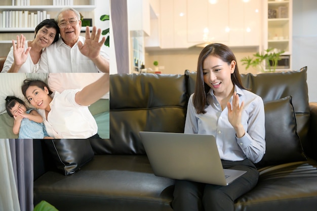 Foto een jonge aziatische vrouw gebruikt laptop computer aan videogesprek of webcam om haar familie, telecommunicatietechnologie, het concept van de ouderschapfamilie te begroeten