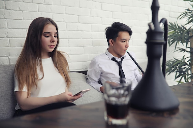 Een jonge Aziatische zakenman wacht op een partner in een café, een zakelijke vergadering in het restaurant, een Koreaanse jongeman die aan de telefoon praat in een café.