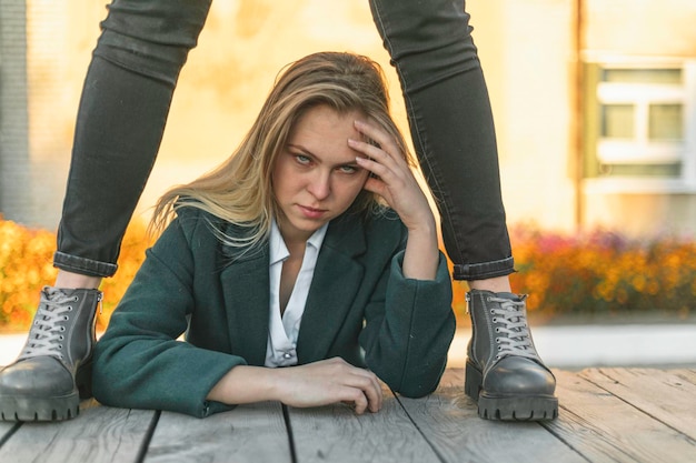 Foto een jonge blanke vrouw met bruin haar is boos ruwe laarzen op het niveau van haar handen