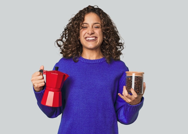 Een jonge blanke vrouw met koffiebonen en een koffiepot