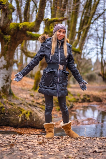 een jonge blonde vrouw in een bos in de herfst