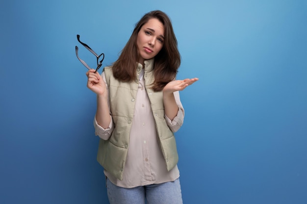 Een jonge brunette vrouw deed haar bril af om te kunnen zien vanwege droge ogen in een studio