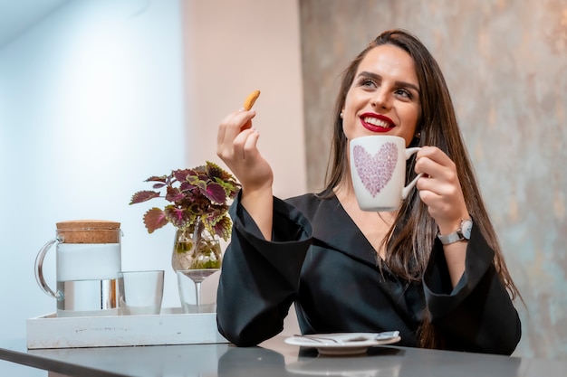 Een jonge brunette vrouw in een cafe met koffie