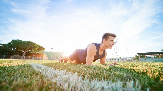 Een jonge doen plank oefening op het stadion