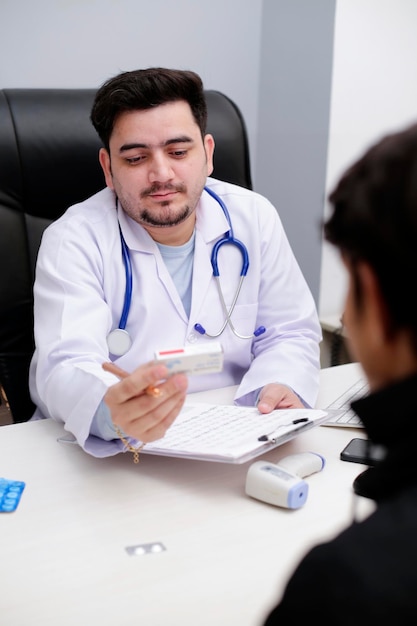 Een jonge dokter is in de kliniek en geeft medicijnen aan de patiënt