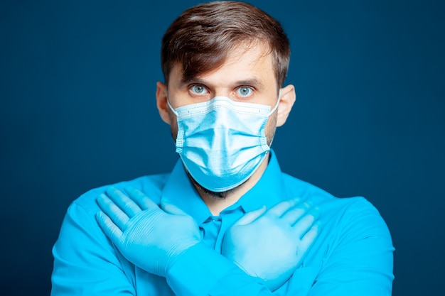 Een jonge dokter met een veiligheidsbril en een medisch masker kruiste haar armen voor haar.