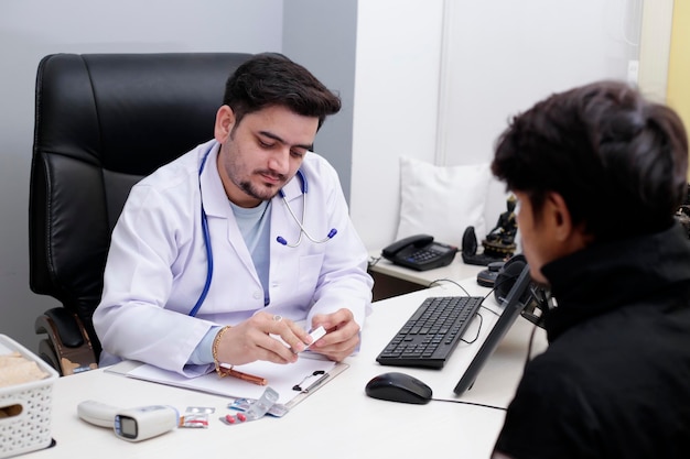 Een jonge dokter zit in de kliniek en houdt medicijnen in de hand