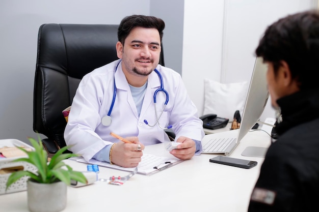 Een jonge dokter zit in de kliniek en praat met de patiënt