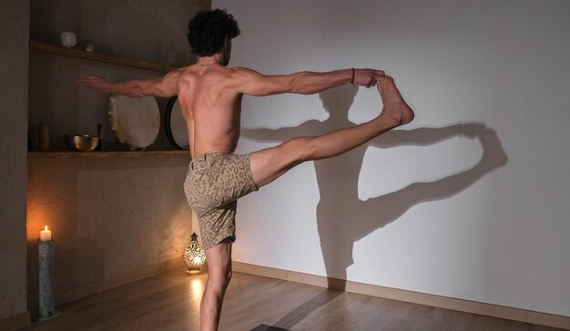 Foto een jonge en atletische man doet yoga en doet asana's.