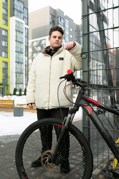 Een jonge Europese man gekleed in een winterjas huurde een fiets voor het weekend.