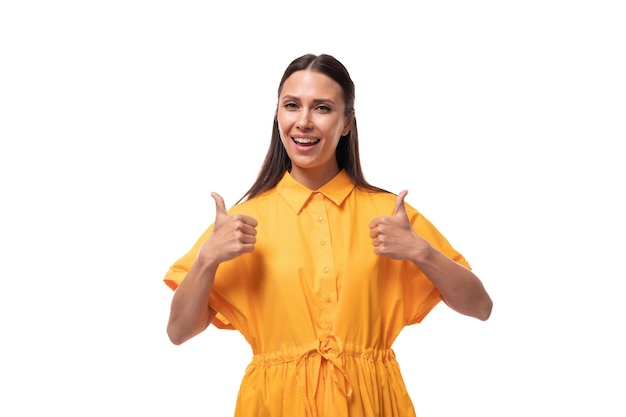 Een jonge Europese vrouw met zwart haar gekleed in een oranje zomerjurk wordt geïnspireerd door een idee en