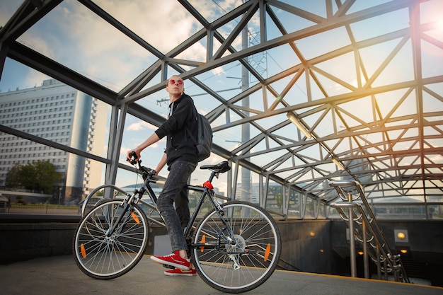 Een jonge fietser onder het glazen dak van de onderdoorgang maakt zich op voor de tocht