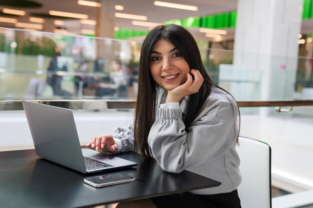 Een jonge freelance vrouw werkt in een winkelcentrum