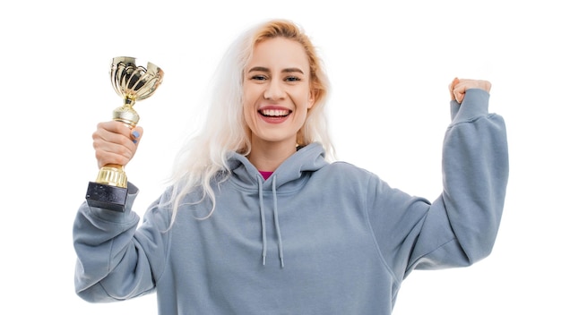 Een jonge gelukkige vrouw met een kopje van de winnaar van de wedstrijd op een witte achtergrond