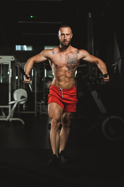 Een jonge gespierde bodybuilder die hard traint voor zijn borstspieren in de sportschool.