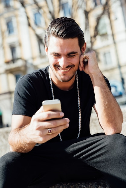 Foto een jonge italiaanse jongen die een smartphone gebruikt