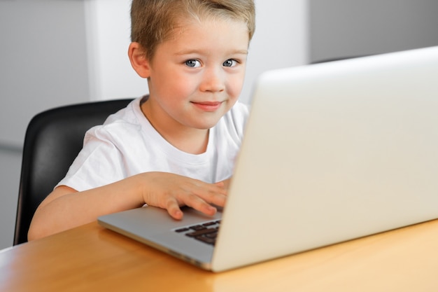 Een jonge jongen die laptop met behulp van