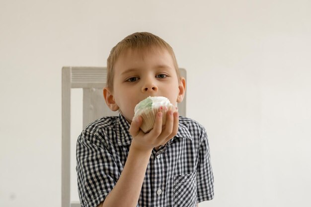 Een jonge jongen eet een taart De eetvreugde van snoep