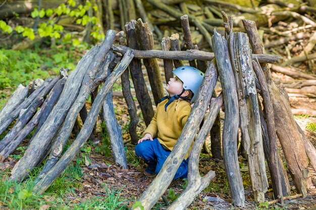 Een jonge jongen speelt in het bos in de zomer of lente.